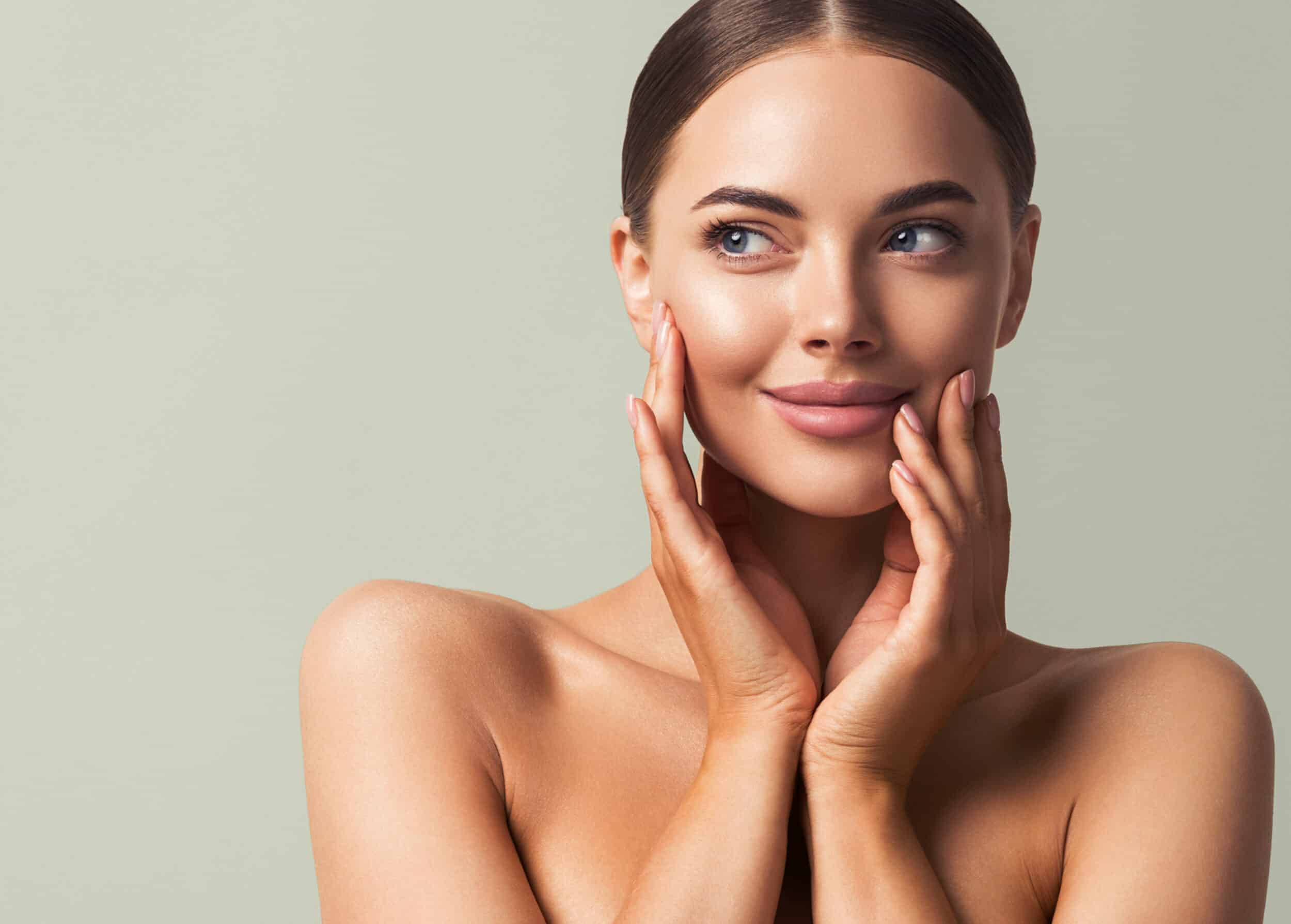 A woman touching her cheeks after buccal fat removal in Lewisville, TX