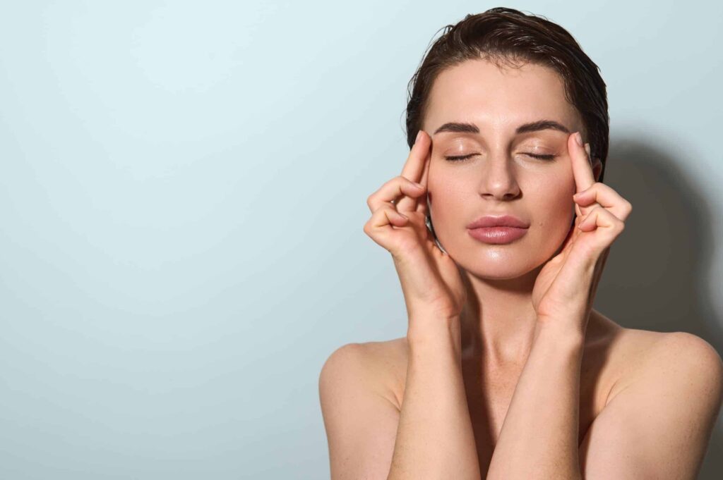 A woman touching her skin after a CO2Lift® Pro session in Lewisville, TX